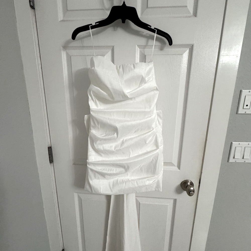 White dress with a cute back bow .